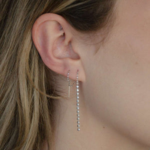 woman wearing sterling silver rhodium plated sleek thread earrings