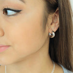 Load image into Gallery viewer, woman wearing sterling silver rhodium plated bubble hoop earrings
