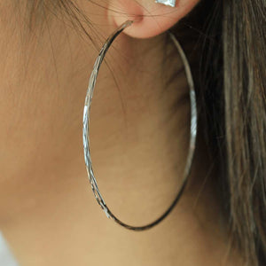 woman wearing sterling silver rhodium plated crushed hoop earrings