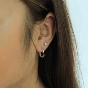 woman wearing sterling silver rhodium plated u-link earrings and cubic zirconia square earrings