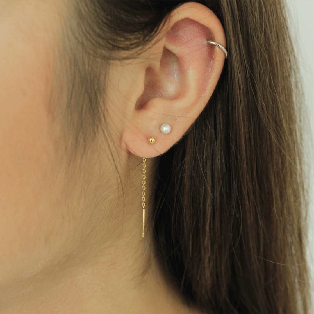 woman wearing sterling silver 18k gold plated stud thread earrings freshwater pearl timeless pearl earrings size 4mm