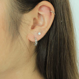 woman wearing sterling silver rhodium plated mini link hoop earrings 